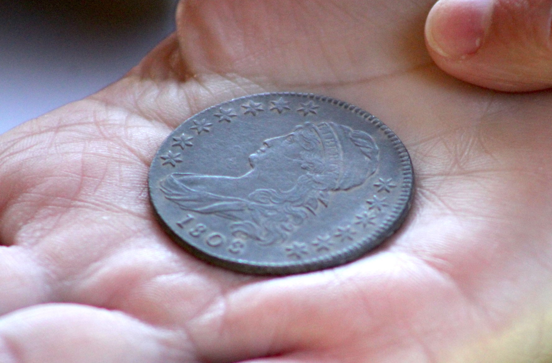 Archaeologist Dr. Julie Schablitsky holds Ben's Cabin coin